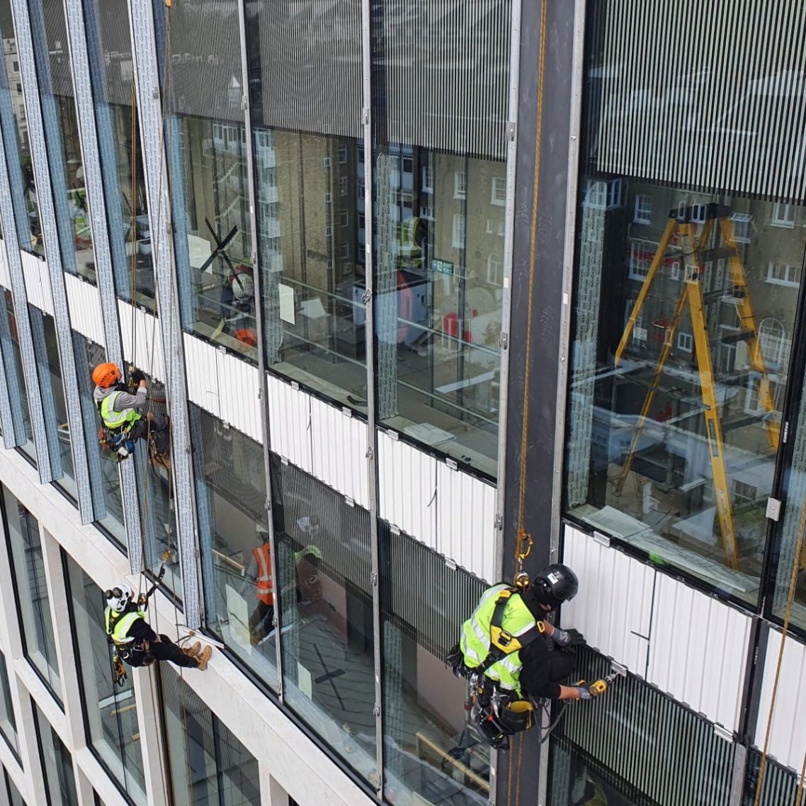IRATA qualified workers cleaning windows on a high-rise building in the city of London.